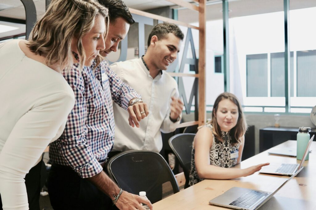 A diverse group of four professionals collaborating at a desk in a modern office.