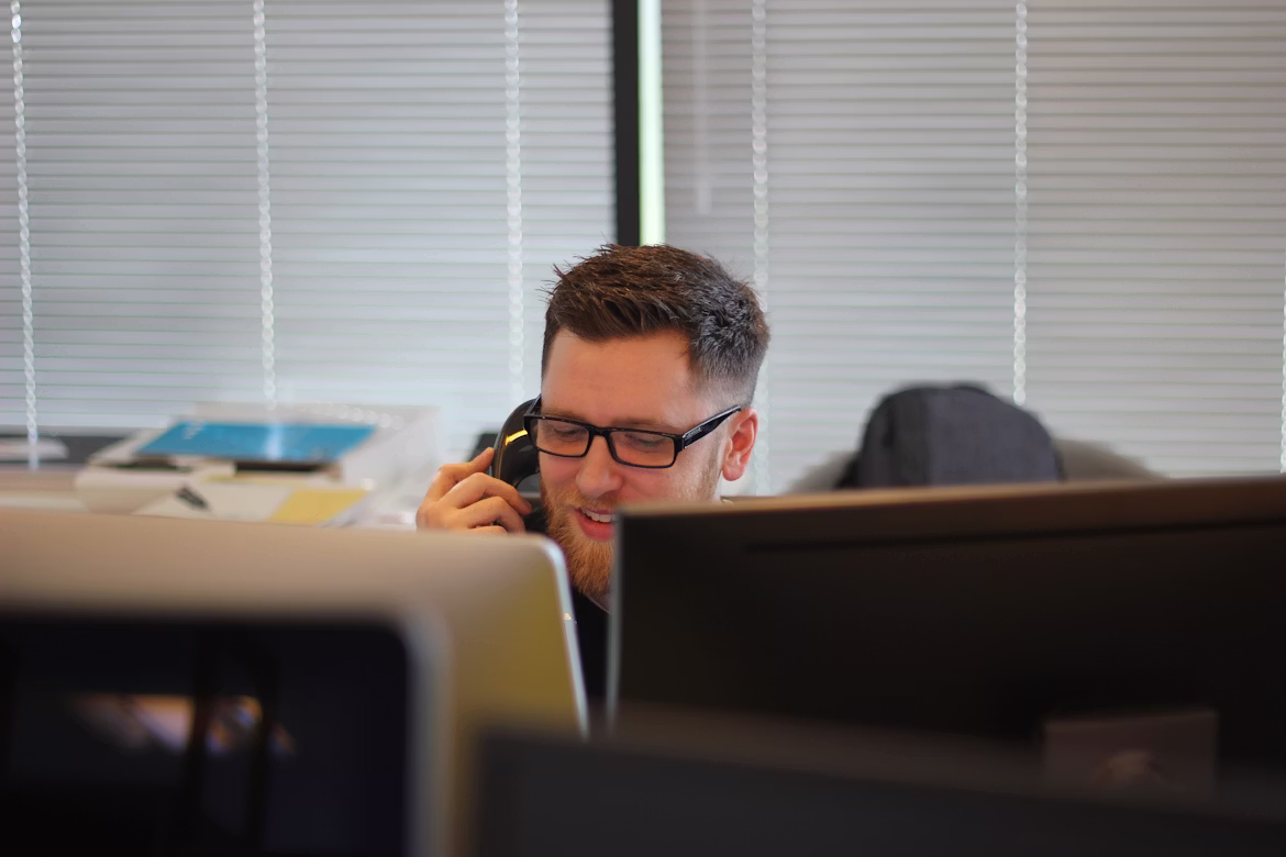 A professional using an enterprise-grade PBX phone system, representing reliable business communication designed by Cree-IT for Northern enterprises.